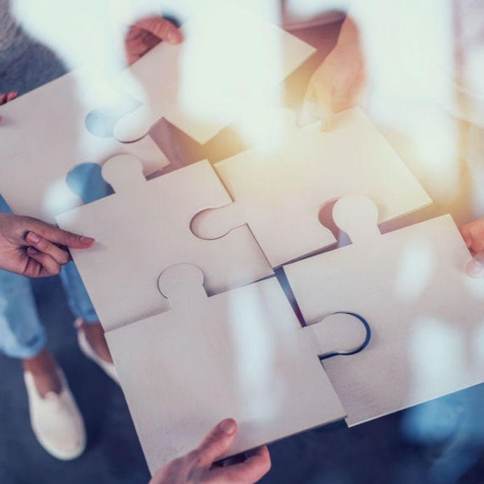 A group of people holding puzzle pieces